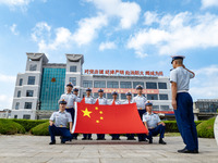 Firefighters pose for a photo with the national flag at the Fire and Rescue Brigade in Xinghua, China, on September 25, 2024. (