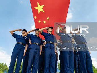 Firefighters pose for a photo with the national flag at the Fire and Rescue Brigade in Xinghua, China, on September 25, 2024. (