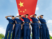 Firefighters pose for a photo with the national flag at the Fire and Rescue Brigade in Xinghua, China, on September 25, 2024. (