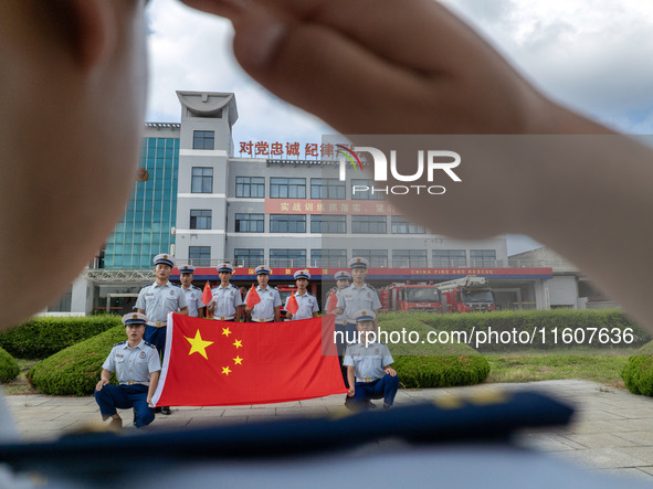 Firefighters pose for a photo with the national flag at the Fire and Rescue Brigade in Xinghua, China, on September 25, 2024. 