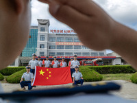 Firefighters pose for a photo with the national flag at the Fire and Rescue Brigade in Xinghua, China, on September 25, 2024. (