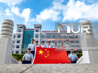 Firefighters pose for a photo with the national flag at the Fire and Rescue Brigade in Xinghua, China, on September 25, 2024. (