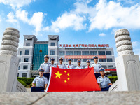 Firefighters pose for a photo with the national flag at the Fire and Rescue Brigade in Xinghua, China, on September 25, 2024. (