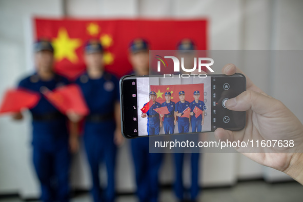 Firefighters pose for a photo with the national flag at the Fire and Rescue Brigade in Xinghua, China, on September 25, 2024. 