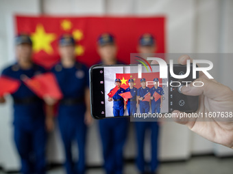 Firefighters pose for a photo with the national flag at the Fire and Rescue Brigade in Xinghua, China, on September 25, 2024. (