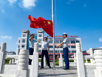 Firefighters pose for a photo with the national flag at the Fire and Rescue Brigade in Xinghua, China, on September 25, 2024. (