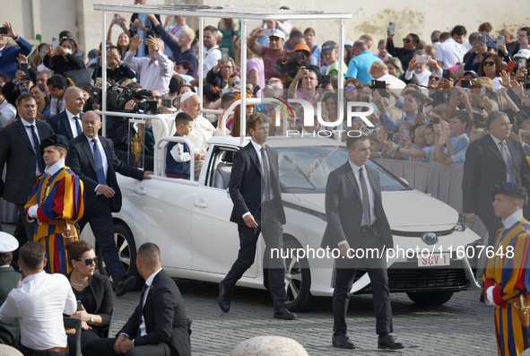 Pope Francis waves to the faithful during the weekly general audience in Saint Peter's Square. 