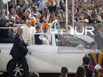 Pope Francis sits on a Toyota Mirai hydrogen-powered popemobile at the end of the weekly general audience in The Vatican, on September 25, 2...