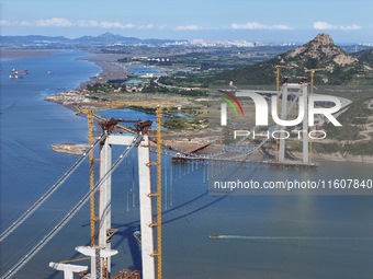 The installation and construction of suspension cables at the construction site of Rushankou Cross Sea Bridge take place in Weihai, China, o...