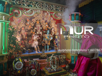 A devotee performs rituals to the idol of the Hindu goddess Durga inside their house, the Hindu goddess of power, ahead of the Durga Puja fe...