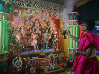 A devotee performs rituals to the idol of the Hindu goddess Durga inside their house, the Hindu goddess of power, ahead of the Durga Puja fe...