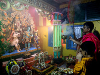 Devotees perform rituals to the idol of the Hindu goddess Durga inside their house, the Hindu goddess of power, ahead of the Durga Puja fest...