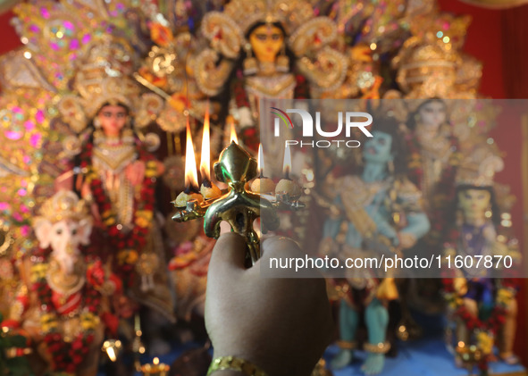 A devotee performs rituals to the idol of the Hindu goddess Durga inside their house, the Hindu goddess of power, ahead of the Durga Puja fe...