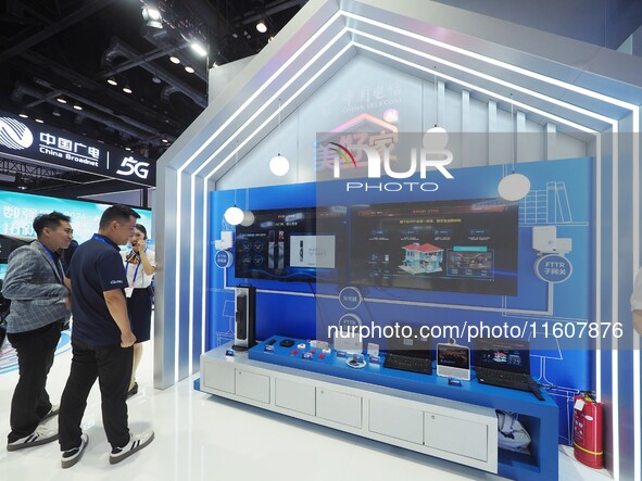 Visitors visit a home digital network system at the booth of China Telecom at the China International Information and Communications Exhibit...