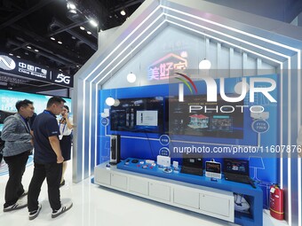 Visitors visit a home digital network system at the booth of China Telecom at the China International Information and Communications Exhibit...