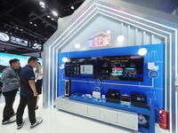 Visitors visit a home digital network system at the booth of China Telecom at the China International Information and Communications Exhibit...