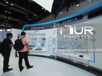 Visitors examine broadband network equipment at the booth of Sintech at the 2024 China International Information and Communications Exhibiti...