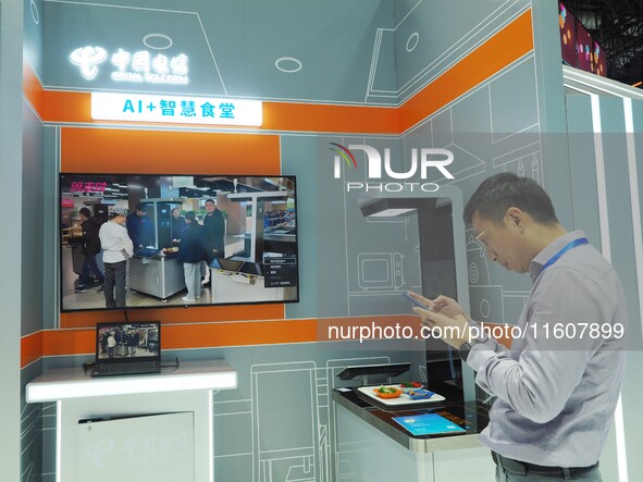 Visitors experience the ''AI+ Smart Canteen'' at the booth of China Telecom at the 2024 China International Information and Communication Ex...