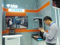 Visitors experience the ''AI+ Smart Canteen'' at the booth of China Telecom at the 2024 China International Information and Communication Ex...