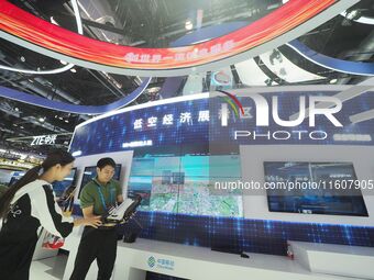 Visitors visit the ''5G+ Connected drone'' at the booth of China Mobile at the 2024 China International Information and Communications Exhib...