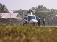 Officials stand near a helicopter used by National Conference Vice President Omar Abdullah during assembly election campaigning in Baramulla...