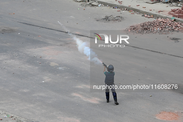 A Bangladeshi policeman fires tear gas shells to disperse anti-quota protesters during a clash at Uttara in Dhaka, Bangladesh, on July 19, 2...