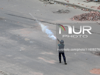 A Bangladeshi policeman fires tear gas shells to disperse anti-quota protesters during a clash at Uttara in Dhaka, Bangladesh, on July 19, 2...