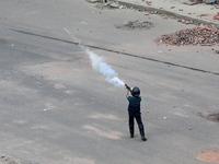 A Bangladeshi policeman fires tear gas shells to disperse anti-quota protesters during a clash at Uttara in Dhaka, Bangladesh, on July 19, 2...