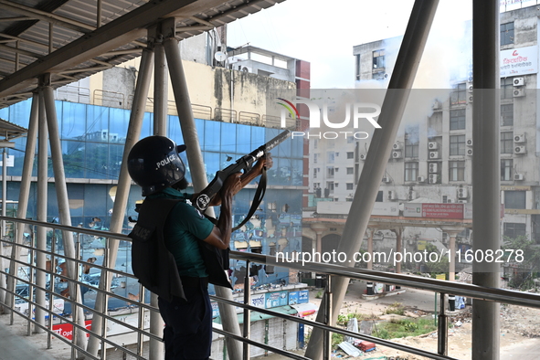 A Bangladeshi policeman fires tear gas shells to disperse anti-quota protesters during a clash at Uttara in Dhaka, Bangladesh, on July 19, 2...