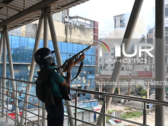 A Bangladeshi policeman fires tear gas shells to disperse anti-quota protesters during a clash at Uttara in Dhaka, Bangladesh, on July 19, 2...