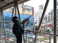 A Bangladeshi policeman fires tear gas shells to disperse anti-quota protesters during a clash at Uttara in Dhaka, Bangladesh, on July 19, 2...