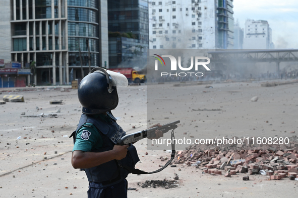 A Bangladeshi policeman fires a rubber bullet to disperse anti-quota protesters during a clash at Uttara in Dhaka, Bangladesh, on July 19, 2...