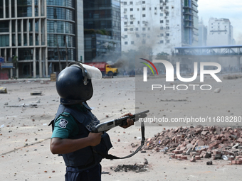 A Bangladeshi policeman fires a rubber bullet to disperse anti-quota protesters during a clash at Uttara in Dhaka, Bangladesh, on July 19, 2...