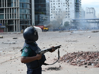 A Bangladeshi policeman fires a rubber bullet to disperse anti-quota protesters during a clash at Uttara in Dhaka, Bangladesh, on July 19, 2...