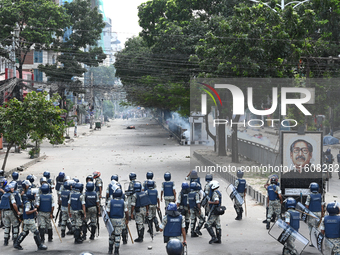 A Bangladeshi policeman fires a rubber bullet to disperse anti-quota protesters during a clash at Uttara in Dhaka, Bangladesh, on July 19, 2...