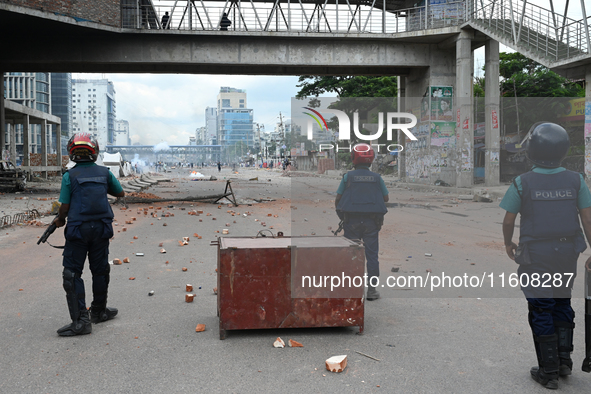 A Bangladeshi policeman fires a rubber bullet to disperse anti-quota protesters during a clash at Uttara in Dhaka, Bangladesh, on July 19, 2...