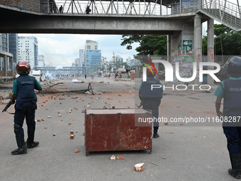 A Bangladeshi policeman fires a rubber bullet to disperse anti-quota protesters during a clash at Uttara in Dhaka, Bangladesh, on July 19, 2...