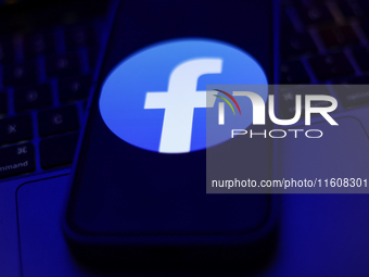 Facebook logo displayed on a phone screen and a laptop keyboard are seen in this illustration photo taken in Krakow, Poland on September 25,...