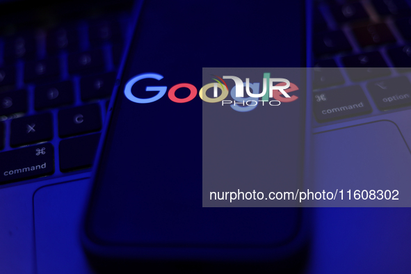 Google logo displayed on a phone screen and a laptop keyboard are seen in this illustration photo taken in Krakow, Poland on September 25, 2...