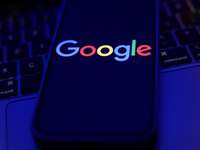 Google logo displayed on a phone screen and a laptop keyboard are seen in this illustration photo taken in Krakow, Poland on September 25, 2...