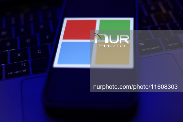 Microsoft logo displayed on a phone screen and a laptop keyboard are seen in this illustration photo taken in Krakow, Poland on September 25...