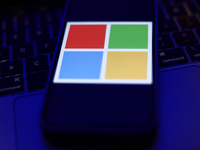 Microsoft logo displayed on a phone screen and a laptop keyboard are seen in this illustration photo taken in Krakow, Poland on September 25...