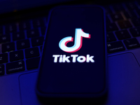 TikTok logo displayed on a phone screen and a laptop keyboard are seen in this illustration photo taken in Krakow, Poland on September 25, 2...