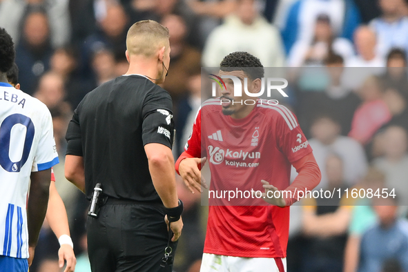 Referee Robert Jones speaks with Morgan Gibbs-White of Nottingham Forest during the Premier League match between Brighton and Hove Albion an...