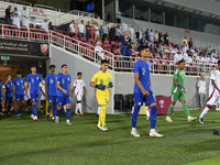 Singapore and Qatar players walk onto the pitch before the 2025 AFC U20 Asian Cup Qualifiers Group J match between Qatar and Singapore at Ab...