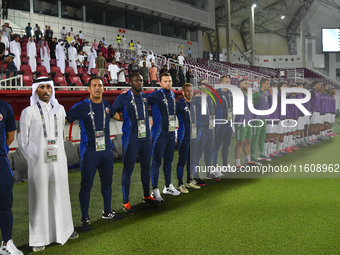 Qatar head coach Felix Angel, his staff, and substitutes line up before the 2025 AFC U20 Asian Cup Qualifiers Group J match between Qatar an...