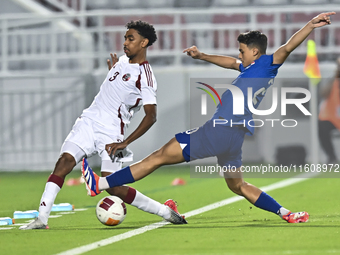 Motaman Mohamed (L) of Qatar battles for the ball with Iryan Fandi (R) of Singapore during the 2025 AFC U20 Asian Cup Qualifiers Group J mat...