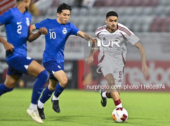 Ibrahim Mohammadali (R) of Qatar battles for the ball with Jonan Tan (L) of Singapore during the 2025 AFC U20 Asian Cup Qualifiers Group J m...