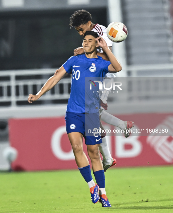 Motaman Mohamed (R) of Qatar battles for the ball with Iryan Fandi (L) of Singapore during the 2025 AFC U20 Asian Cup Qualifiers Group J mat...