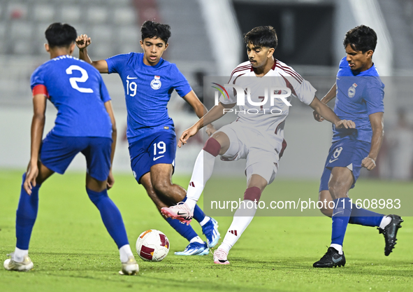 Tahsin Mohammed Jamshid (C) of Qatar battles for the ball with Sahoo Garv (2-L) of Singapore during the 2025 AFC U20 Asian Cup Qualifiers Gr...